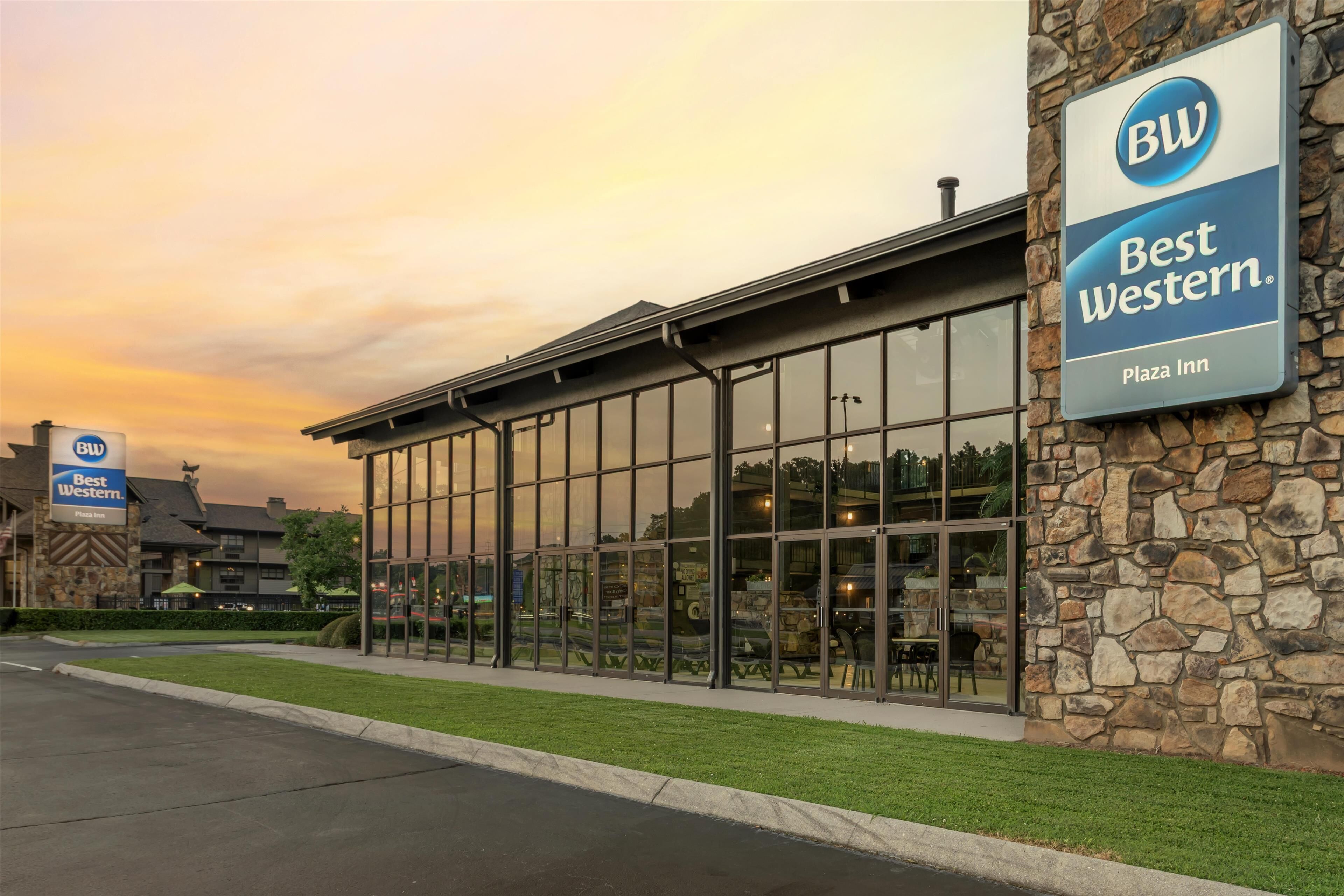 A Best Western Plaza Inn with a stone facade and large glass windows reflecting the interior.