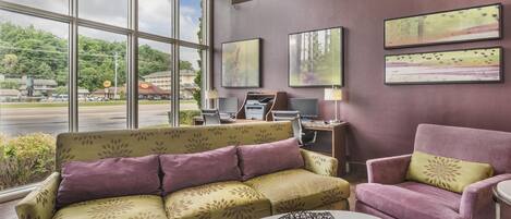 A modern hotel lobby with a sofa, armchair, and a coffee table.