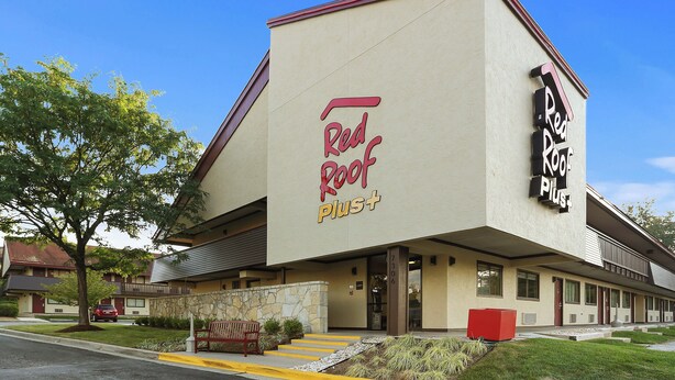 Edifici amb un rètol que diu 'Red Roof Plus' i façana de pedra.