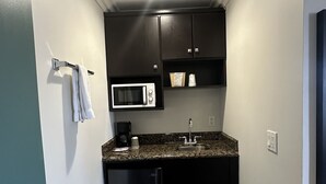 A compact kitchen with a microwave, sink, and refrigerator.
