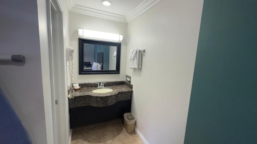 A bathroom with a sink, mirror, and towel rack.