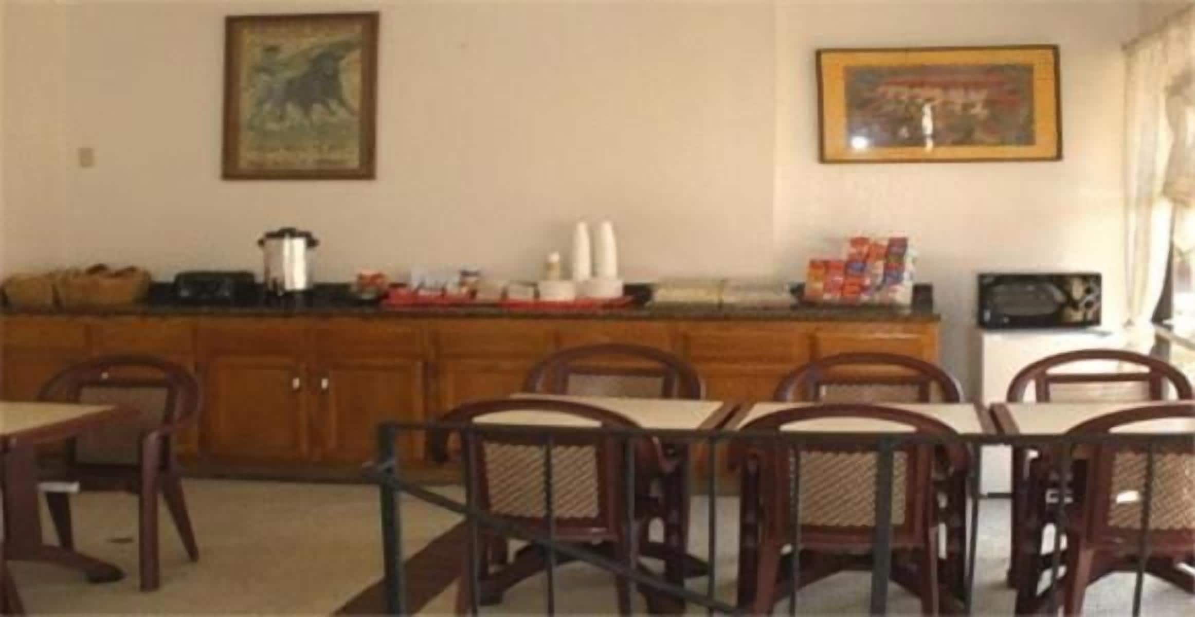 A dining area with wooden cabinets, a kitchen counter, and a dining table with chairs.