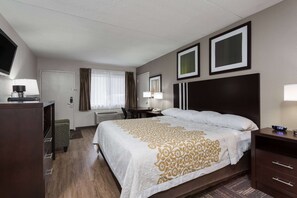 A hotel room with a bed, a desk, a chair, a TV, and a window with curtains. - Days Inn by Wyndham Harrisburg North (Harrisburg)