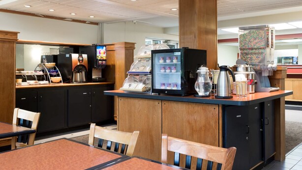 A hotel lobby with a reception desk, seating area, and vending machines. - Days Inn by Wyndham Harrisburg North (Harrisburg)