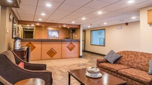 A lobby with a reception desk, seating area, and a coffee machine. - Best Western Inn & Suites (Ontario)