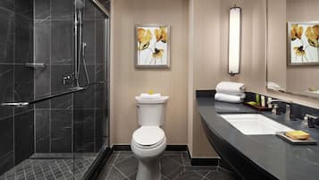 A modern bathroom with a shower, toilet, and sink.