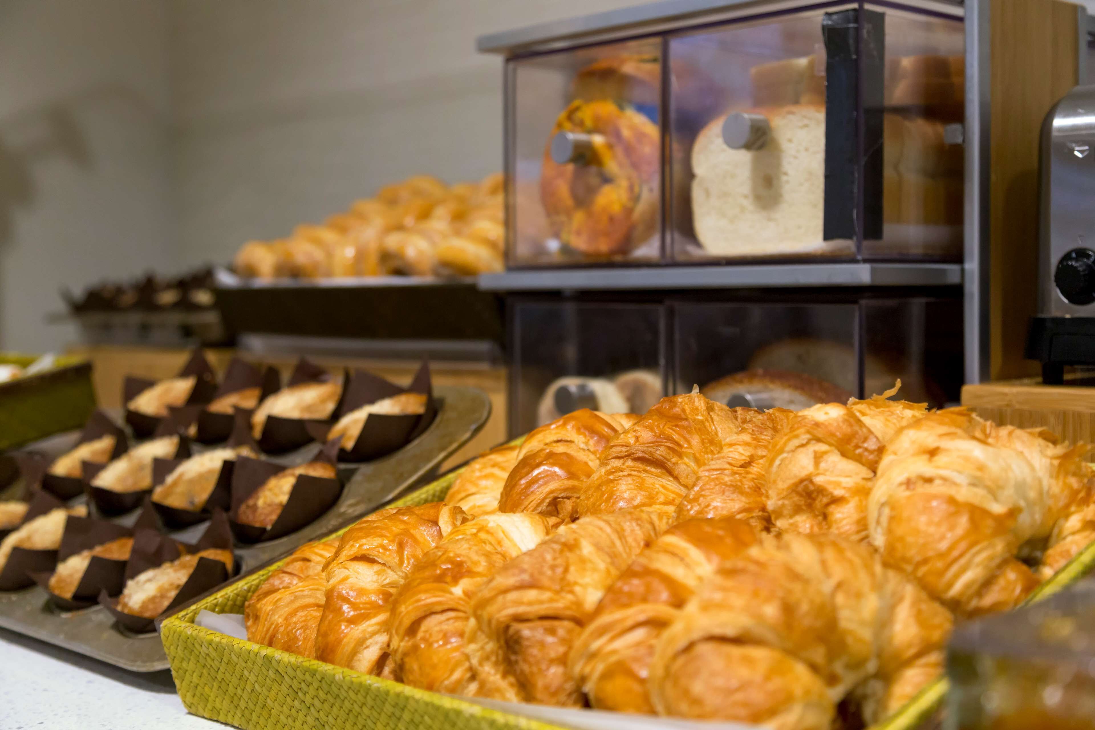 Une variété de produits de boulangerie est exposée, notamment des croissants et du pain.