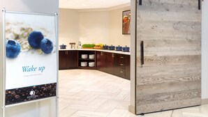A modern kitchen with wooden cabinets, a herringbone floor, and a sliding barn door.