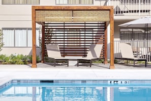 Una piscina al aire libre, tumbonas