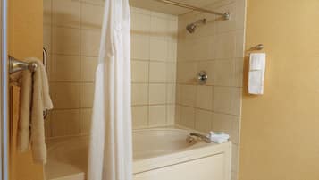 Une salle de bain avec une baignoire, une douche et un porte-serviettes.