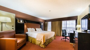 Une chambre d’hôtel avec un lit, un bureau, une chaise et un téléviseur.