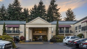 A hotel entrance with a parking lot, a building number 24415, and a row of parked cars. - Best Western Plus Plaza by the Green (Kent)