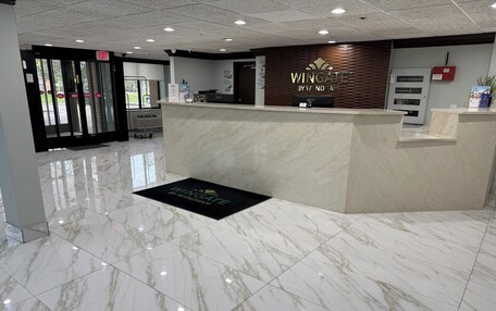 A reception area with a marble floor, a reception desk, and an exit sign.