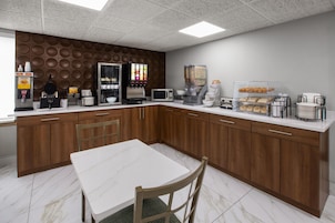 A modern kitchen with a white marble countertop, wooden cabinets, and a central island with seating.