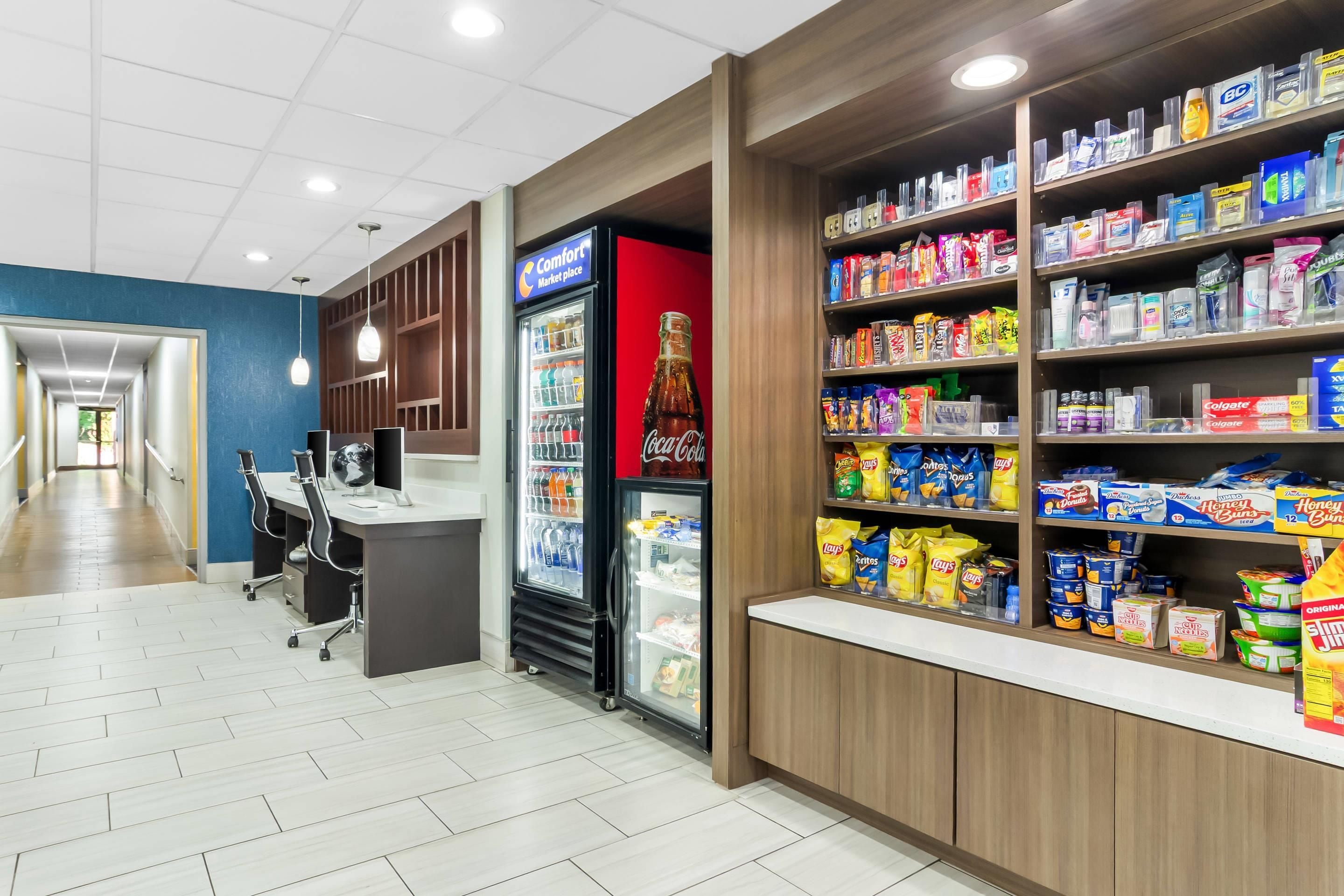 A clean, well-lit convenience store with a variety of snacks, beverages, and toiletries on shelves.