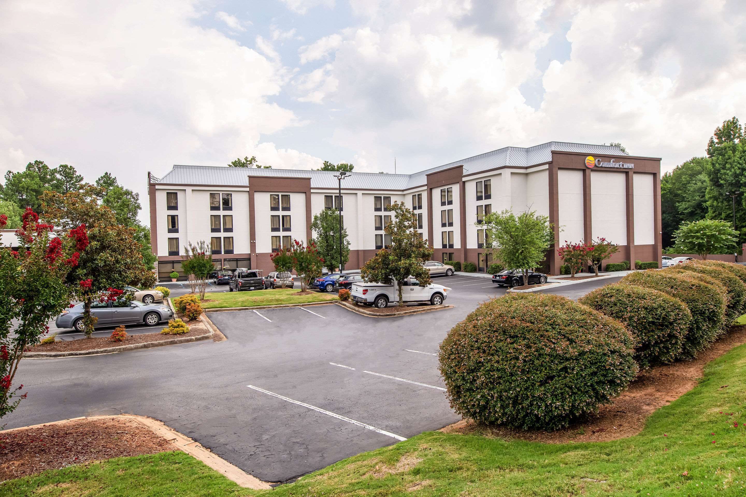A hotel with a parking lot, multiple buildings, and well-maintained landscaping.