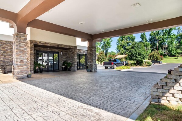 A covered outdoor area with a stone facade, a bench, and a truck parked nearby. - Comfort Inn Greenville - Haywood Mall (Greenville)