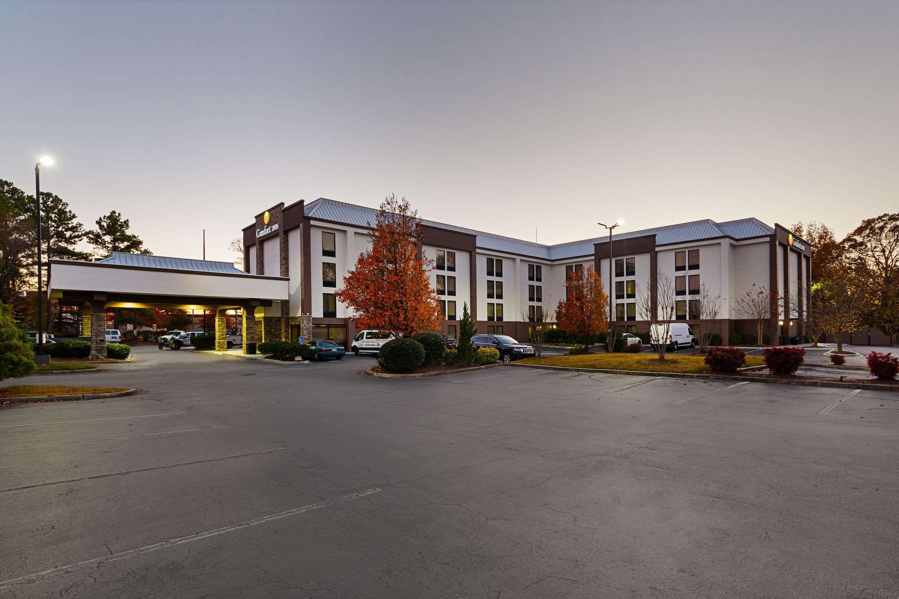 A hotel with a central courtyard, multiple parking spaces, and a covered entrance.