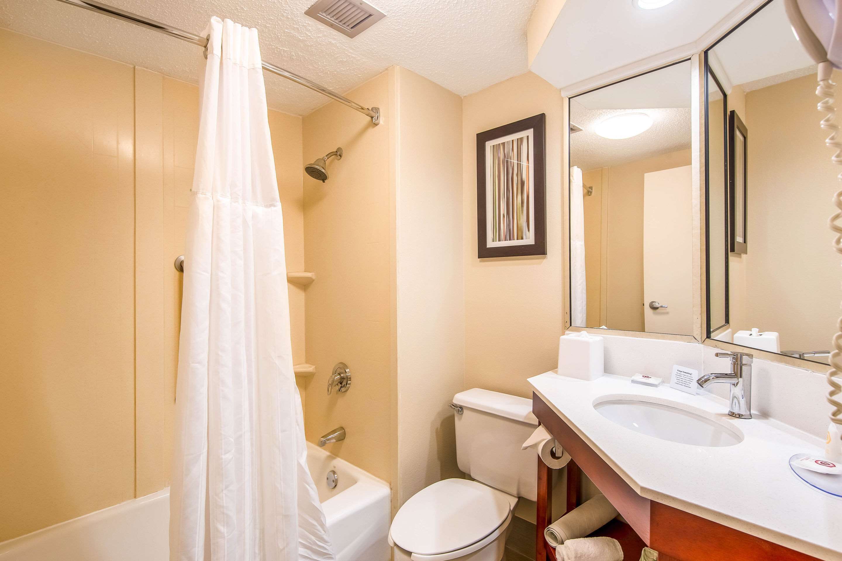 A bathroom with a bathtub, toilet, and sink.