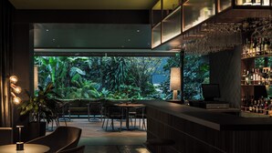 Un bar moderno con vistas a un exuberante follaje.