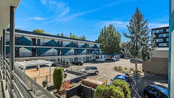A motel with multiple rooms, a parking lot, and a large tree.