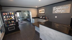 A modern reception area with a vending machine, a counter, and a sign reading "Eastside Lodge".
