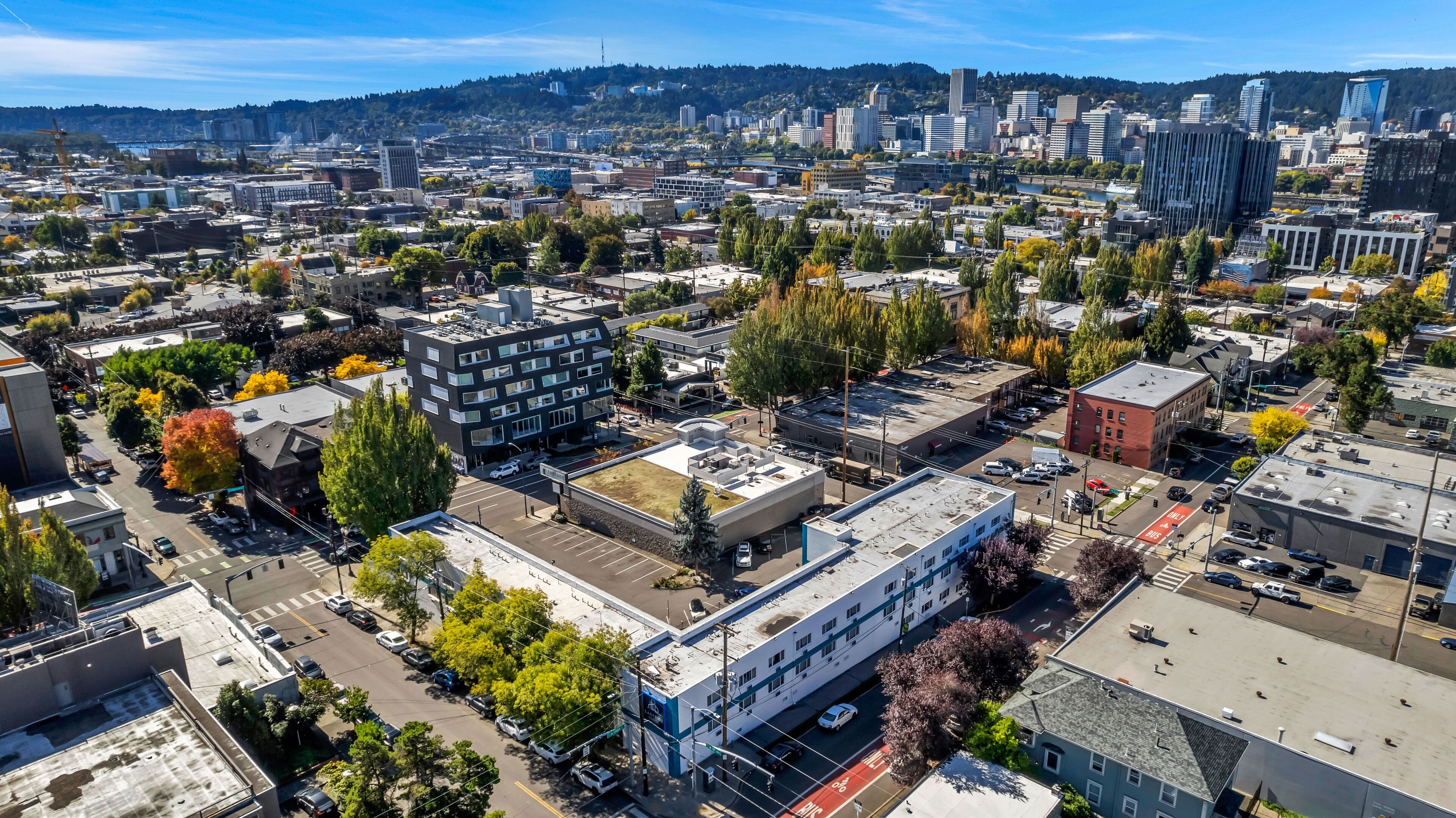 An aerial view of a cityscape with various buildings, roads, and trees.