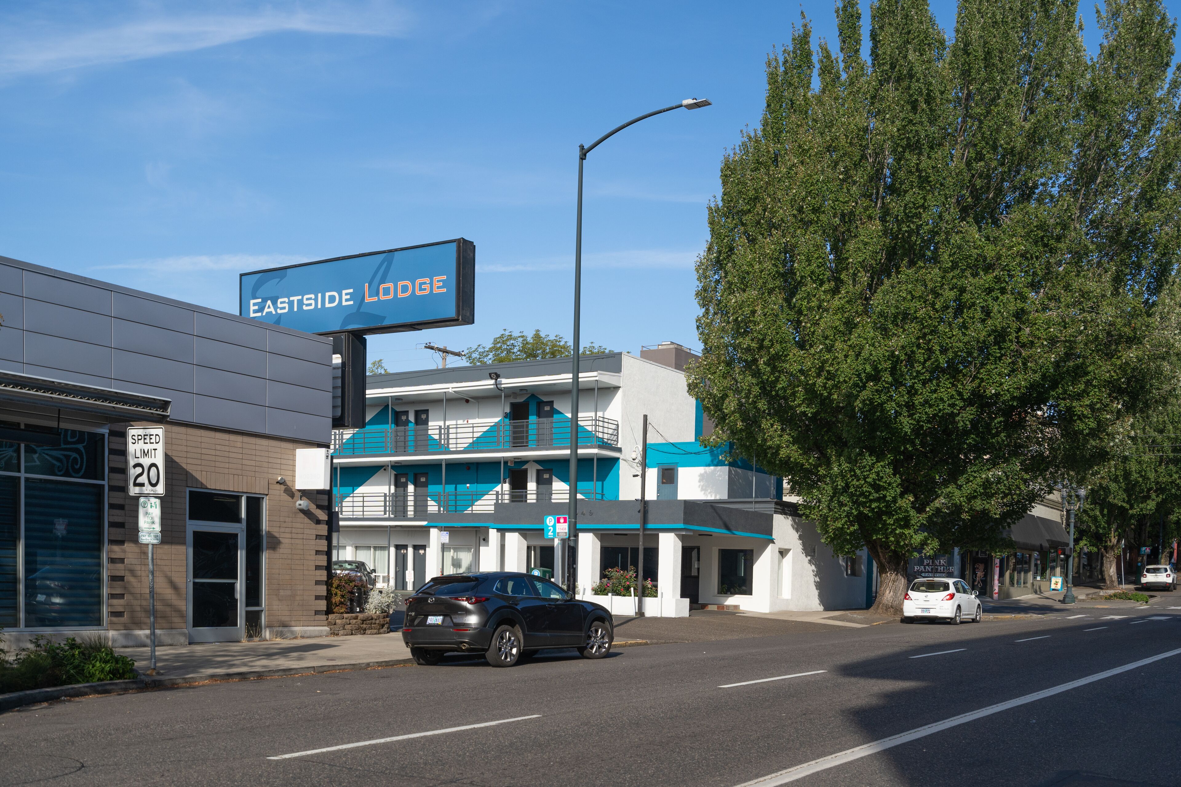A building with a sign reading "EASTSIDE LODGE" and a speed limit sign of 20.