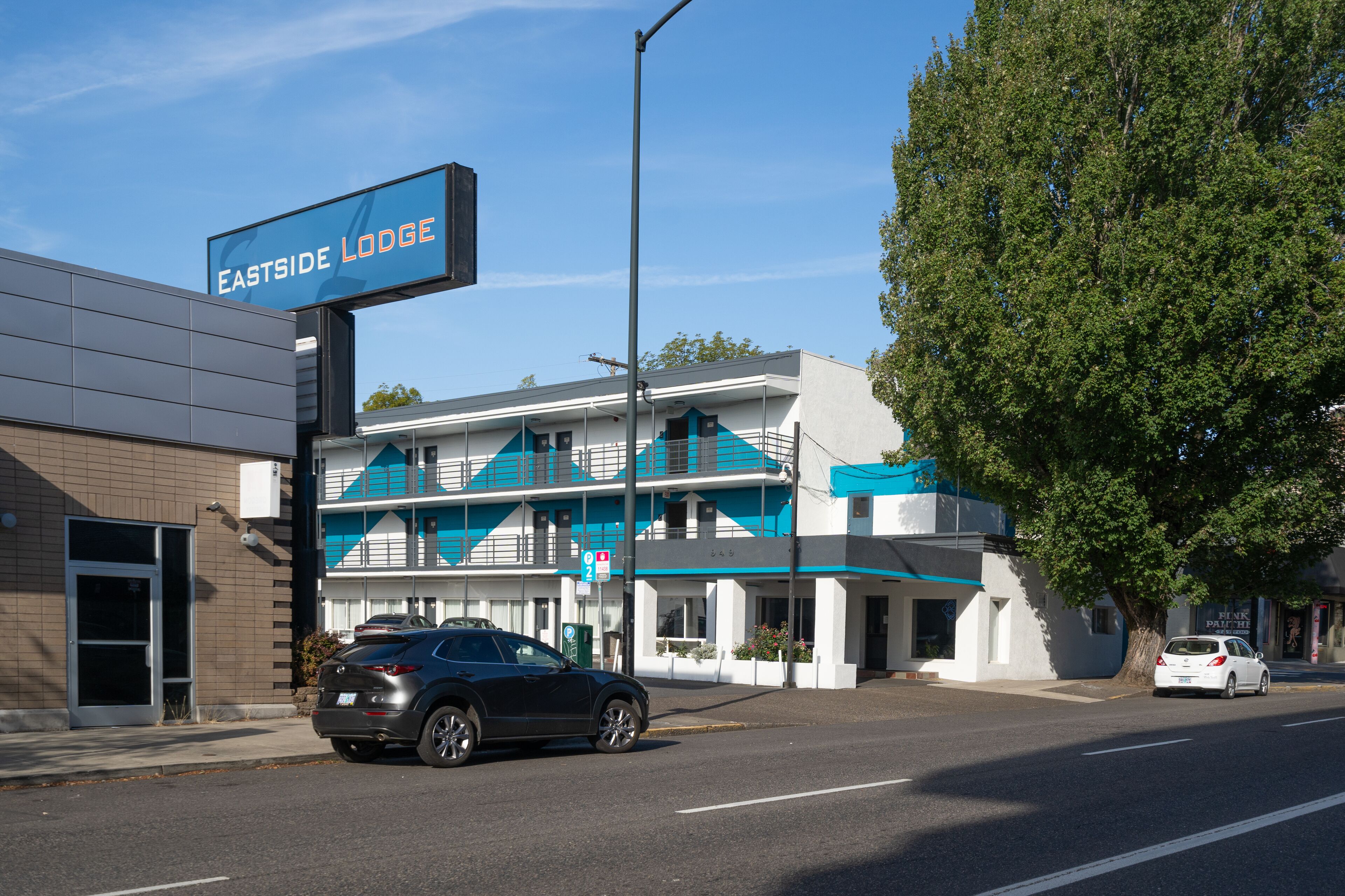 A building with a sign reading "Eastside Lodge" and a modern architectural style with a blue and white color scheme.