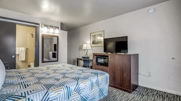 Een hotelkamer met een bed, een bureau, een televisie en een spiegel.