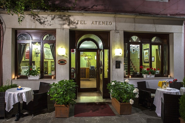 The exterior of Hotel Ateneo with a welcoming entrance, potted plants, and outdoor seating area. - Hotel Ateneo (Venice)