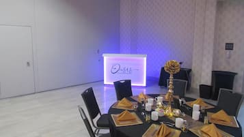 A conference room with a podium labeled 'Oasis' and tables set for a meeting.