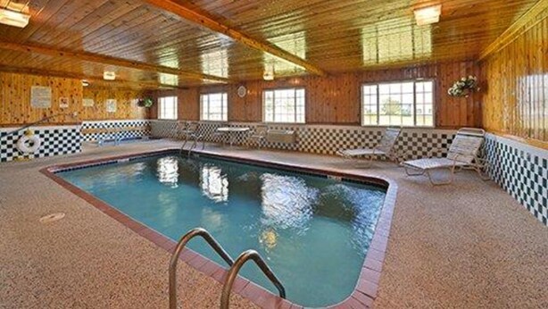 An indoor swimming pool with checkered floor tiles, wooden walls, and a ceiling with wooden beams. - Quality Inn & Suites Grinnell near University (Grinnell)