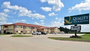 A hotel with a sign reading "Quality Inn & Suites" featuring a two-story building with a red roof and multiple windows. - Quality Inn & Suites Grinnell near University (Grinnell)