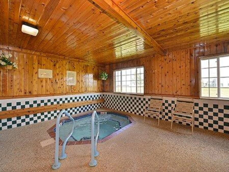 A wooden interior with a checkered floor, a pool, and benches.