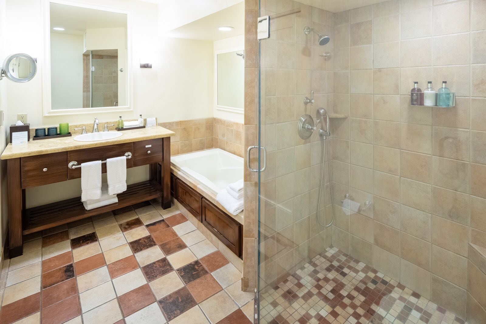 A bathroom with a sink, mirror, and a glass-enclosed shower area.