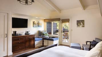 Une chambre à coucher avec un lit, un bureau avec une chaise, une fenêtre donnant sur un beau paysage et un téléviseur fixé au mur.