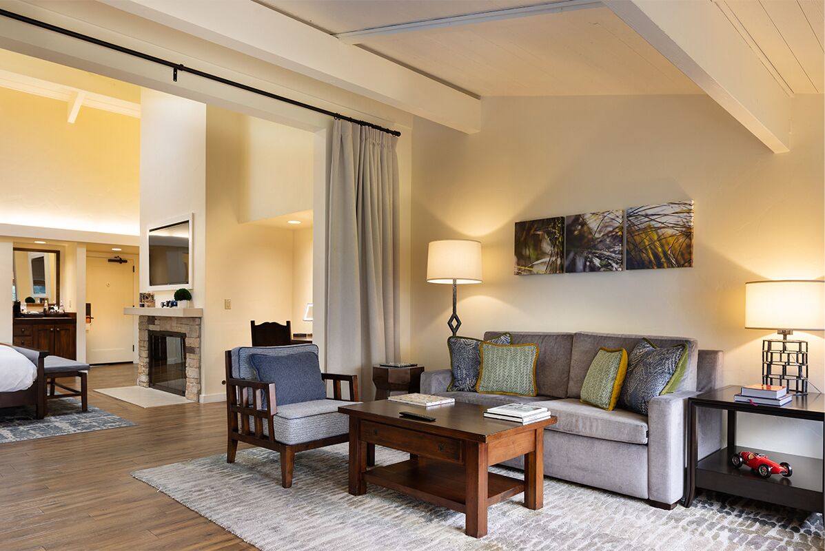 Una sala de estar moderna con un sofá, sillones, una mesa de centro y una chimenea.