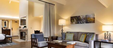 Una sala de estar moderna con un sofá, sillones, una mesa de centro y una chimenea.