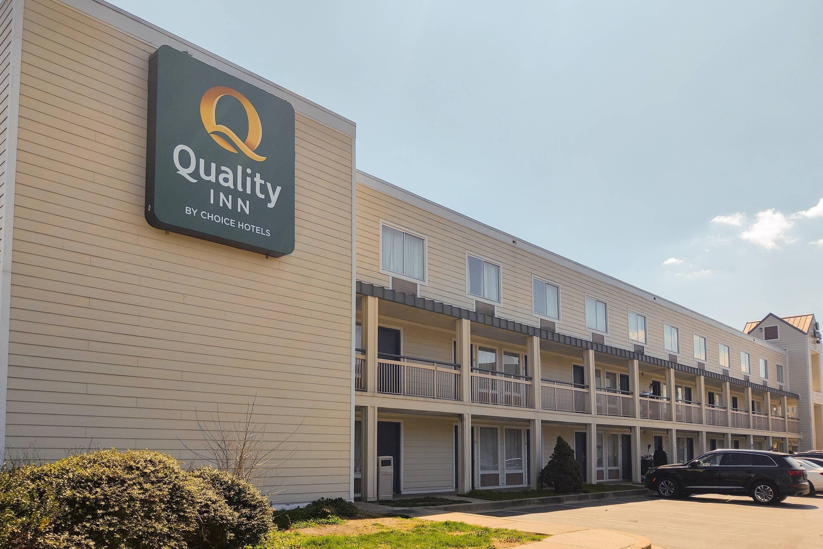 Een meerlaags hotel met een bordje waarop 'Quality Inn by Choice Hotels' staat.