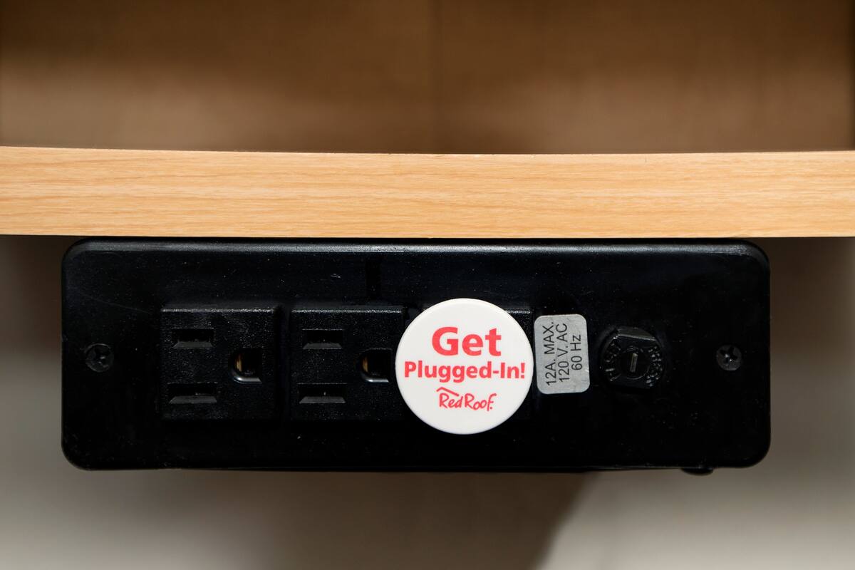 A power strip with a plug-in button and a label indicating 120V AC and 60 Hz.