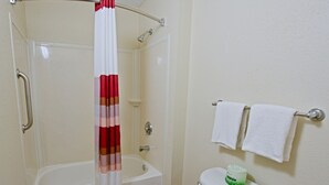 A bathroom with a shower, toilet, and a towel rack. - Red Roof Inn Akron (Akron)