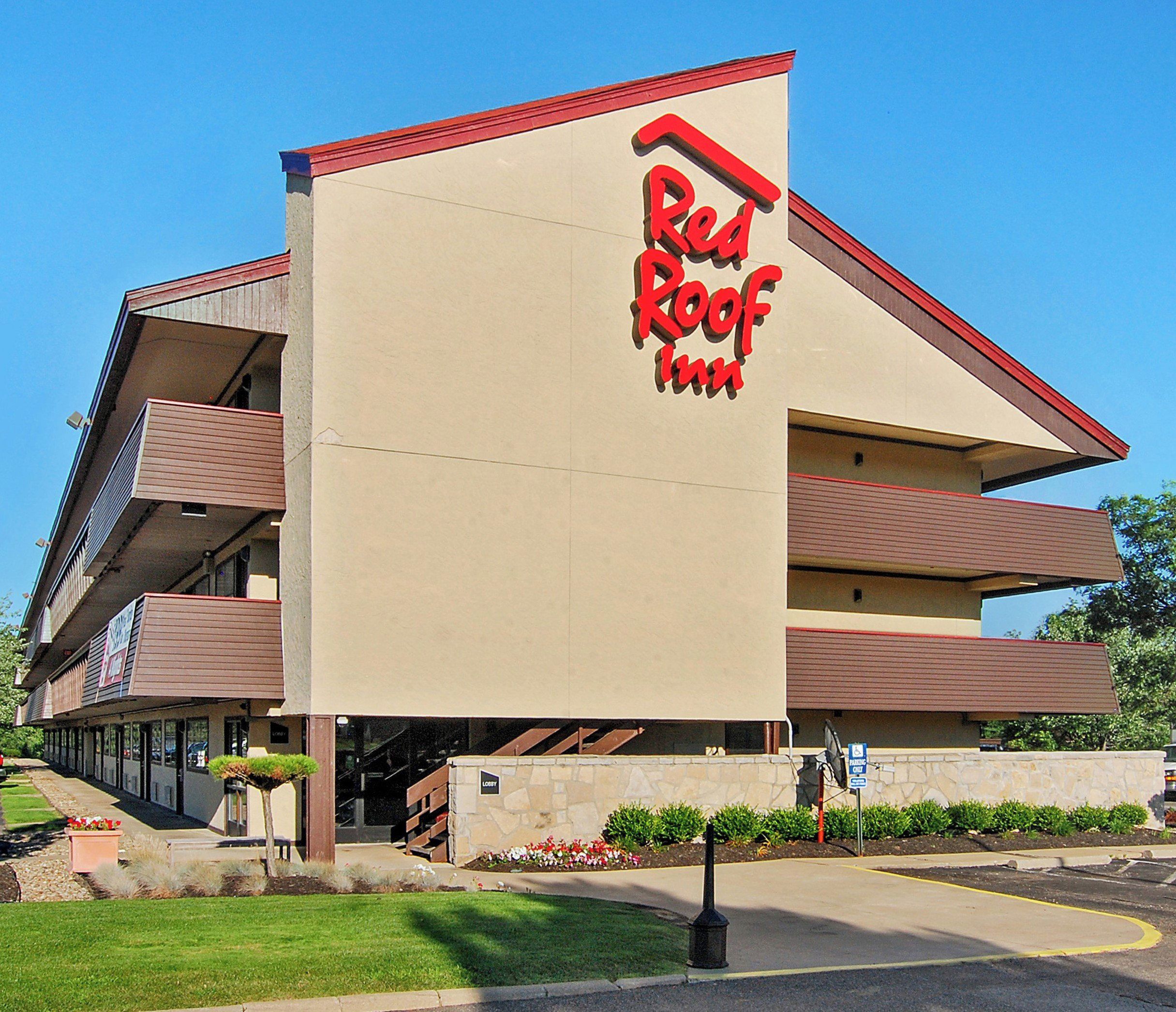 A Red Roof Inn with a modern architectural design, featuring a prominent red roof and a sign with the inn's name.