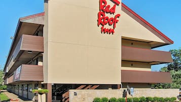 A Red Roof Inn with a modern architectural design, featuring a prominent red roof and a sign with the inn's name.