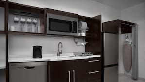 Una cocina moderna con electrodomésticos de acero inoxidable, lavavajillas y horno empotrado.