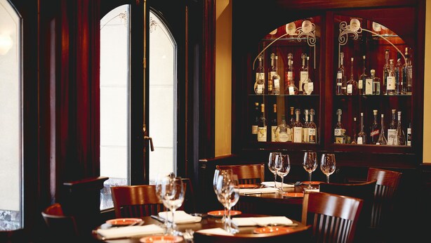 A restaurant with a bar area, wooden furniture, and a view through a large window. - Kimpton Hotel Vintage Seattle by IHG (Seattle)