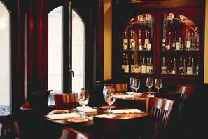 A restaurant with a bar area, wooden furniture, and a view through a large window. - Kimpton Hotel Vintage Seattle by IHG (Seattle)