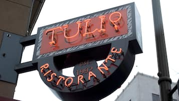 A neon sign for a restaurant named 'TULIP' with 'EST. 1992' indicating its establishment year.
