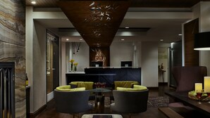 A modern hotel lobby with a reception desk, two armchairs, a coffee table, and a fireplace. - Kimpton Hotel Vintage Seattle by IHG (Seattle)