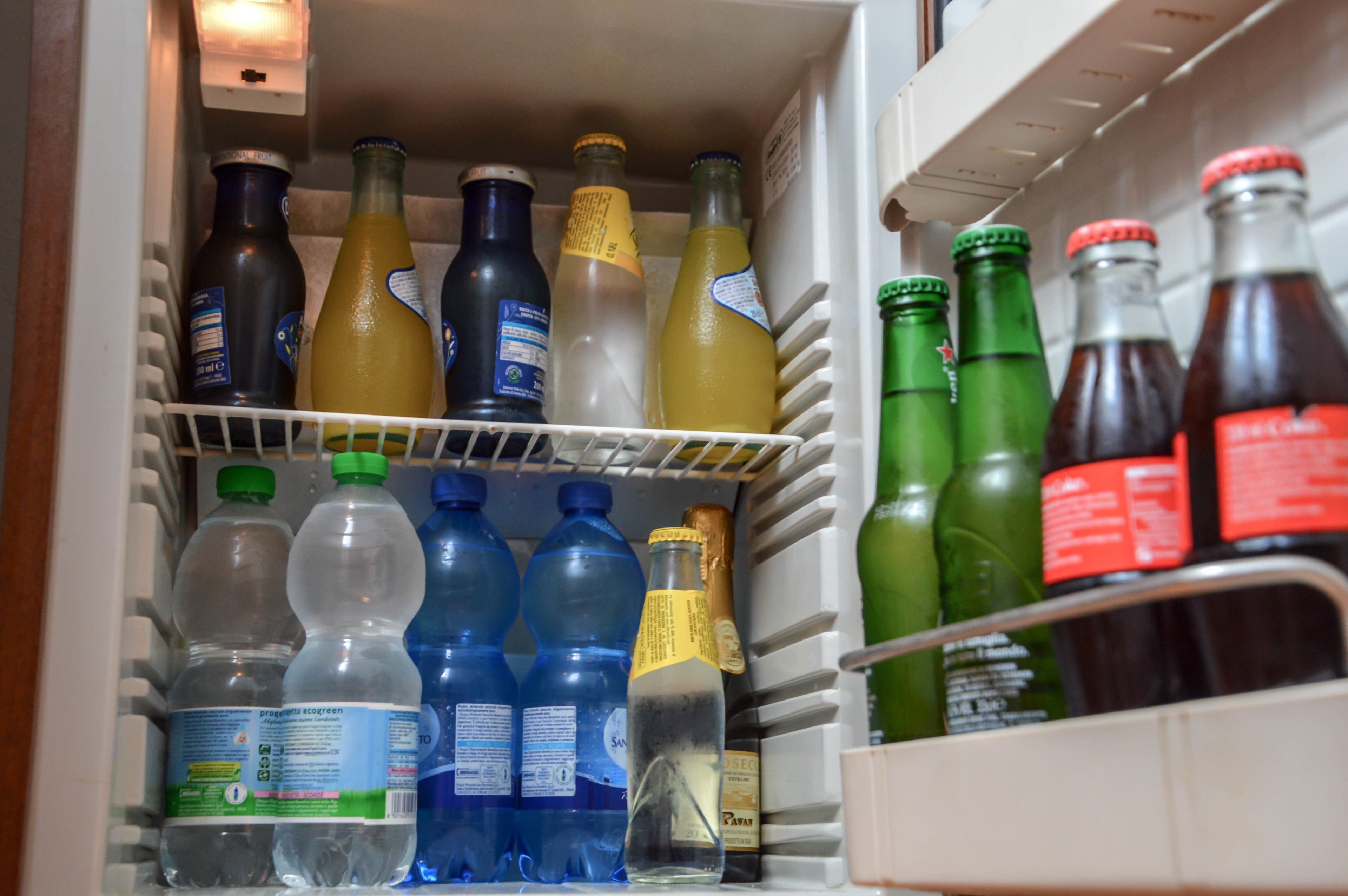A refrigerator stocked with various beverages including water, juice, and soda.